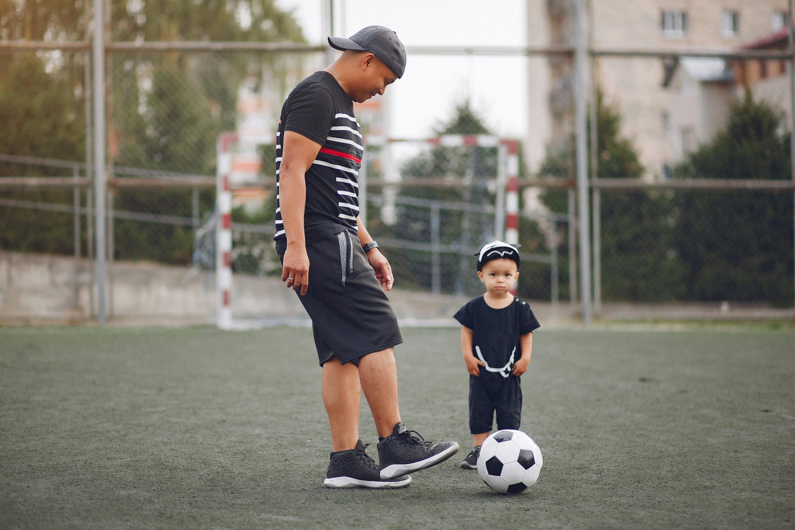 “Padre e hijo con ropa deportiva — conexión familiar a través del fútbol.”